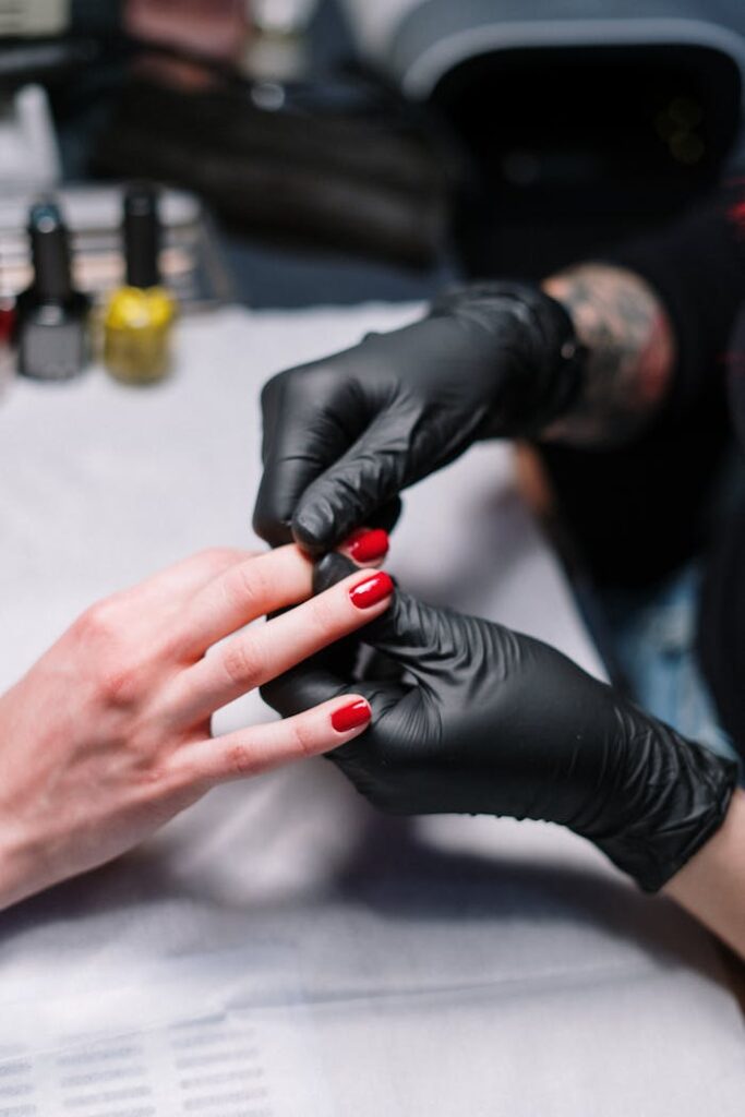 Person in Black Gloves Massaging Fingers